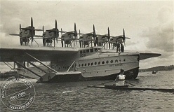 Ein Ruderer beobachtet das berühmte Flugzeug DoX nach der Landung auf dem Wasser
